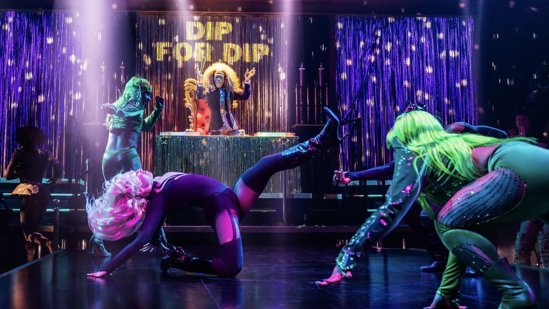 Dip for Dip moment from Cats: The Jellicle Ball, with the campaign signage centered in the ballroom finale